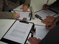 Firmando contratos. Aparecen varios contratos superpuestos.