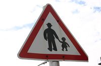 Señal de peligro. Señal de aviso de peligro de abuelos paseando con sus nietos.