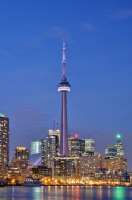 Vista de la ciudad de Toronto de noche con mucha iluminación reflejandose en el mar.