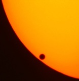 Imagen de un cuarto aproximadamente del sol, donde se puede apreciar una pequeña sombra redonda que corresponde al transito de Venus.