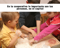 Dos niños y una niña amasando en clase y con cartel sobre la foto que dice: En la cooperativa lo importante son las personas, no el capital.