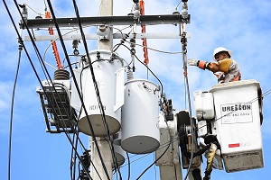 Imagen de un electricista trabajando en una línea de alta tensión.