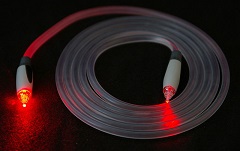 Imagen de una fibra óptica. Puede verse la luz roja en los dos extremos de la fibra.