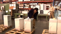 Imagen que muestra a un operario manipulando unas cajas sobre un palé.