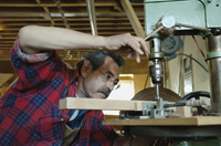 Imagen de un carpintero perforando una pieza de madera.