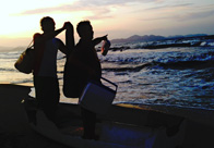 Dos personas disfrutando de un atardecer en la playa.