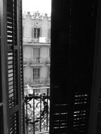 Fotografía desde una ventana en la que se puede ver la fachada de enfrente de un edificio de Barcelona.