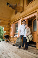 Fotografía de una pareja en la entrada de una casa de madera.