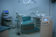 Visión general del gabinete dental con el sillón dental, sus complementos, láser y terminal informático al fondo.