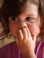 Fotografía de una niña pequeña que está hurgándose la nariz.