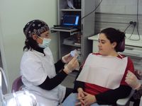 Una odontóloga que trabaja en Dentoclínic, le está explicando a una paciente el tratamiento de ortodoncia que necesita.