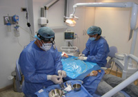 Sedación profunda. Fotografía en la que se ve el anestesista realizando una sedación profunda a una paciente odontológica.
