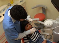 Higienista y paciente en el sillón del gabinete dental.