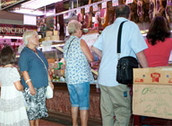 Grupo de personas comprando en un puesto.