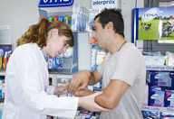 Profesional sanitaria con paciente examinadole el brazo.