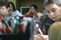 Un grupo de chicos y chicas en una clase estudiando.