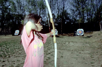 Chica tirando con un arco a una diana.