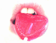 Se ven unos labios mordiendo una piruleta.