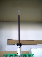 Se observa una pipeta llena de sangre e introducida en tubos de tapón negro, colocada de forma vertical. La pipeta esta graduada.