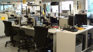 En la imagen se muestra el aspecto de la sala principal de un laboratorio de citogenética con gran cantidad de microscopios y monitores donde se realizan los estudios.