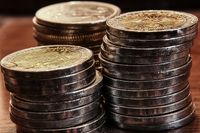Monedas apiladas. Fotografía que muestra en primer plano tres montones de monedas apiladas.