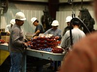 Cadena de producción. Fotografía en la que se pueden ver varios trabajadores en una cadena de producción de una fabrica.