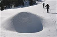 Foto de dos personas esquiando sobre una densa nieve. 