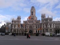 Banderas de España y de la Unión Europea en la calle, delante del  palacio de Cibeles en Madrid.