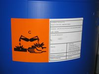 Foto de la etiqueta de un contenedor para productos corrosivos,  con la apariencia normalizada de seguridad para este tipo de productos. 
