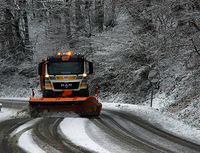 Máquina quitanieves en una carretera nevada