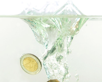 Una moneda de euro sumergiéndose en el agua.