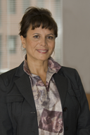 Retrato de una mujer de mediana edad con chaqueta oscura y pelo recogido.